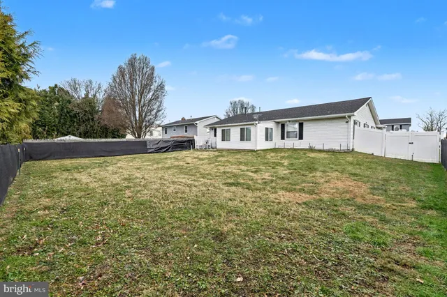 a view of a house with a big yard and large trees