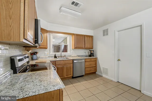 a kitchen with granite countertop a sink stove and cabinets