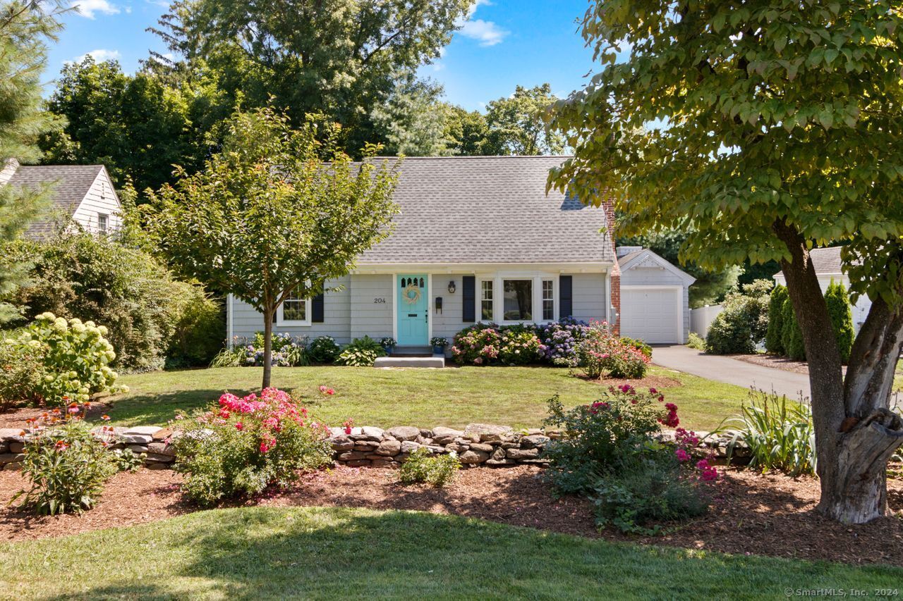 a front view of a house with a yard and potted plants