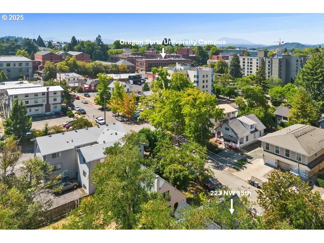 an aerial view of residential house with outdoor space and trees all around