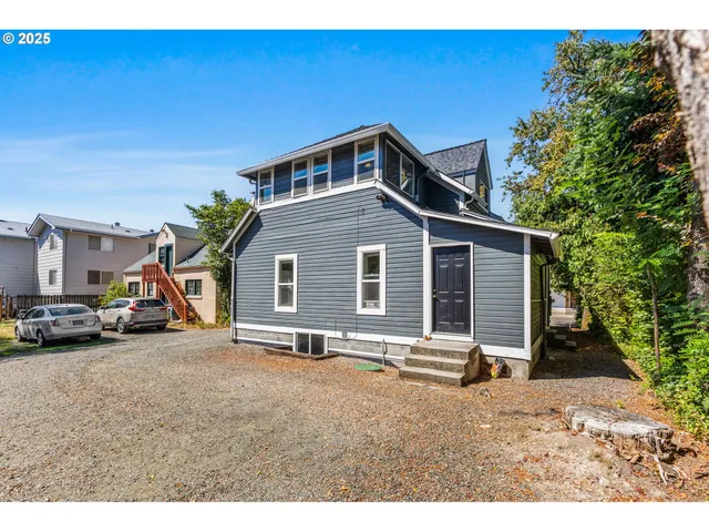 a view of a house with backyard and a wooden fence
