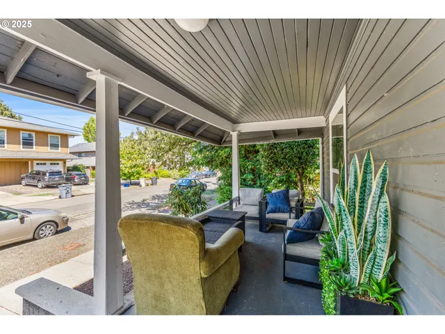 a view of a patio with couches chairs potted plants and floor to ceiling window