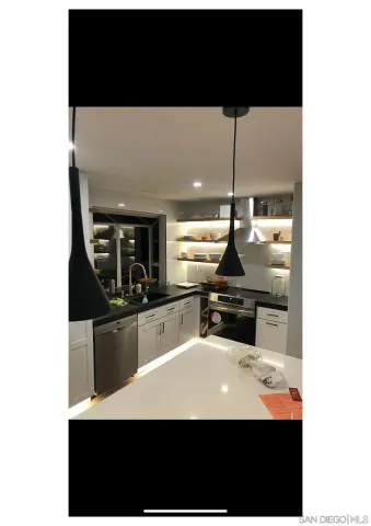 a kitchen with a sink a counter top space and stainless steel appliances