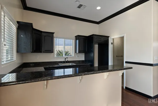 an empty room with windows and ceiling fan