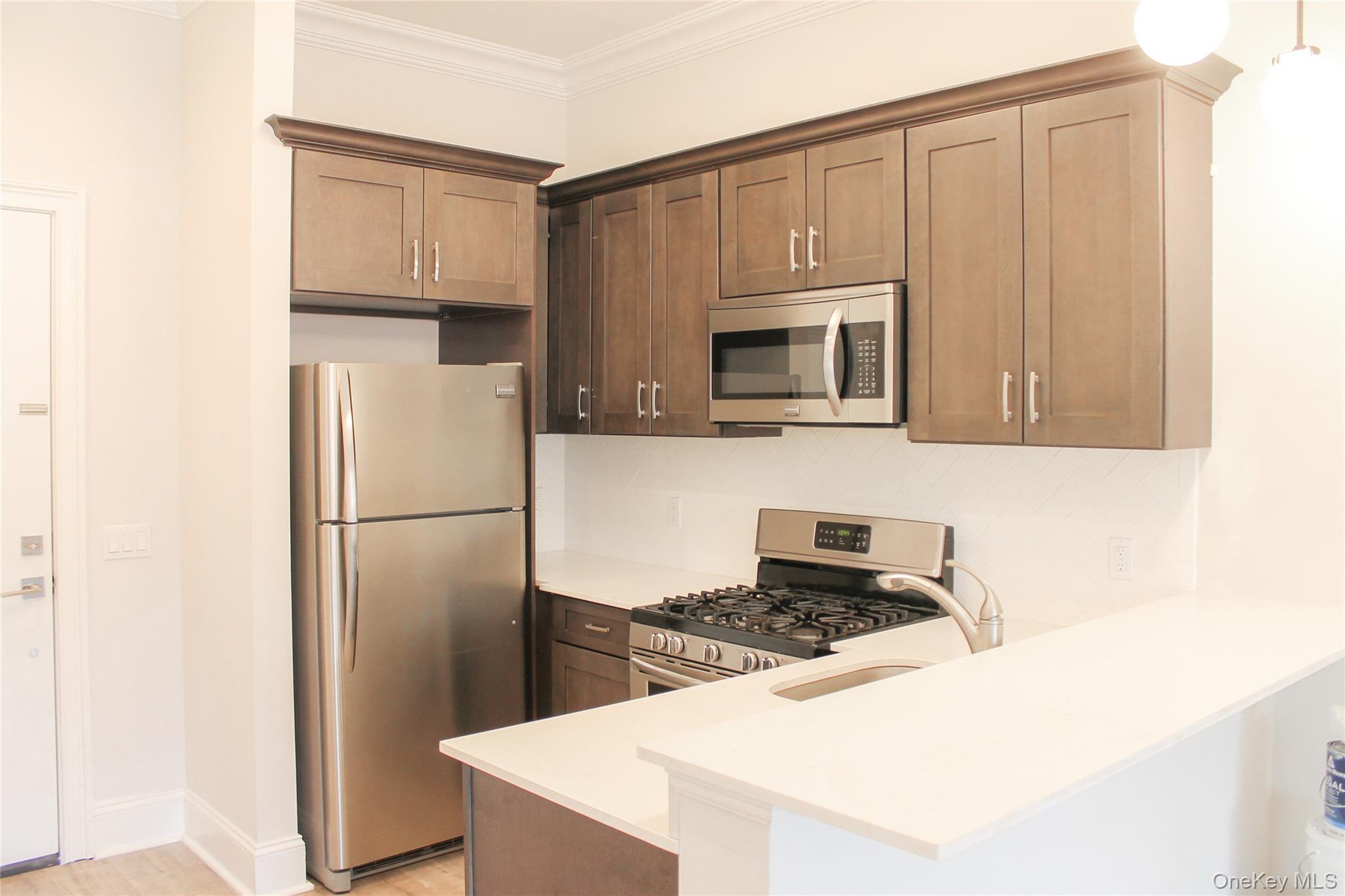 226 New York Avenue, Unit 302 Huntington, NY 11743 - Photo 4 of 11 a kitchen with a refrigerator stove and microwave