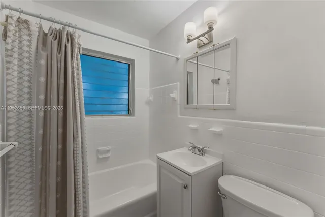 a kitchen with stainless steel appliances granite countertop a refrigerator a sink and white cabinets