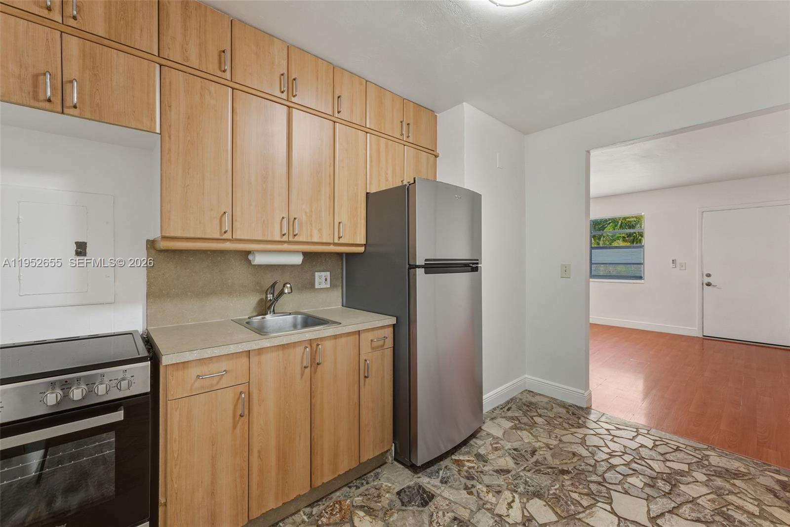 645 Northeast 77th Street, Unit 17 Miami, FL 33138 - Photo 6 of 12 a kitchen with stainless steel appliances granite countertop a refrigerator a sink and white cabinets