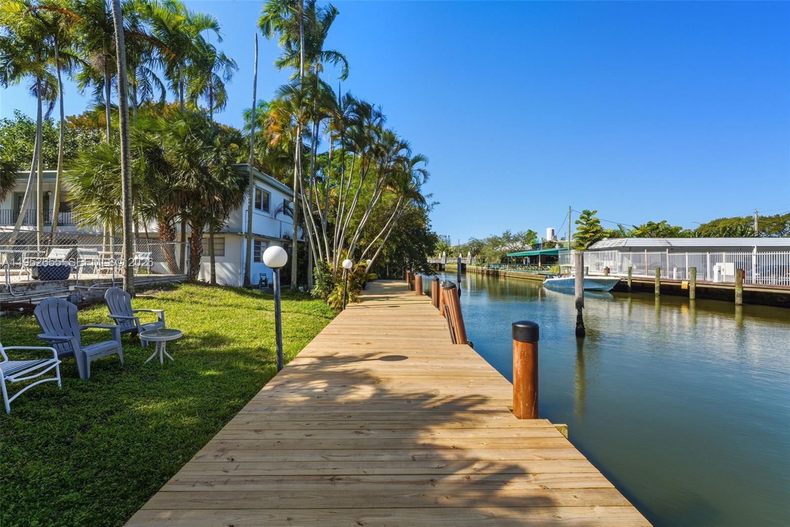 645 Northeast 77th Street, Unit 17 Miami, FL 33138 - Photo 10 of 12 a view of a lake with a yard and palm trees