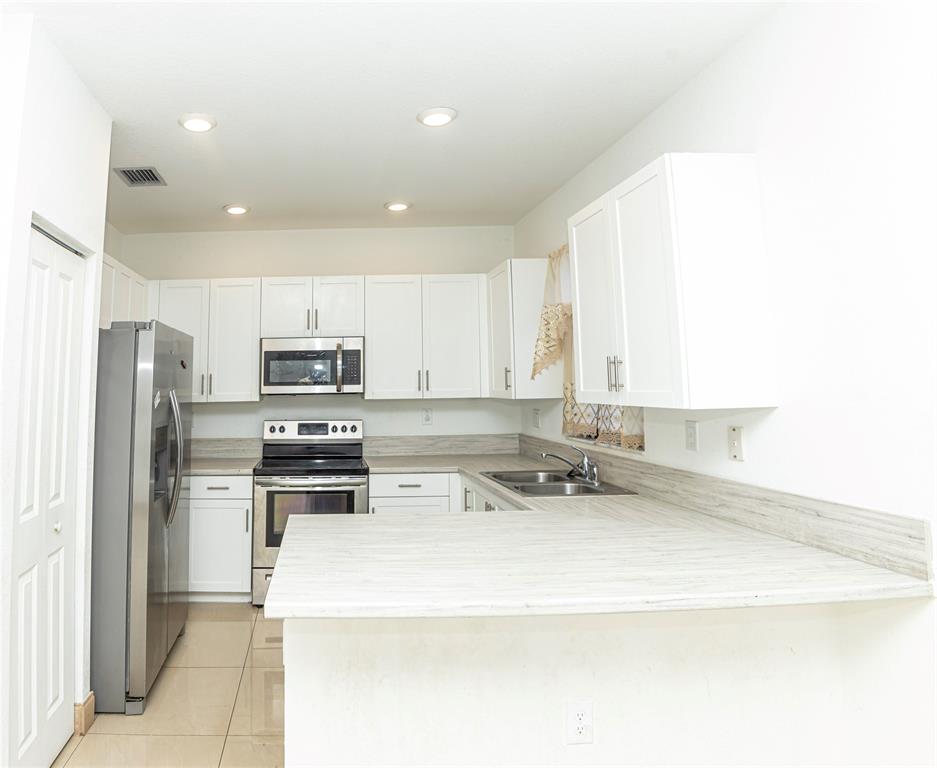 a kitchen with stainless steel appliances a refrigerator sink and microwave