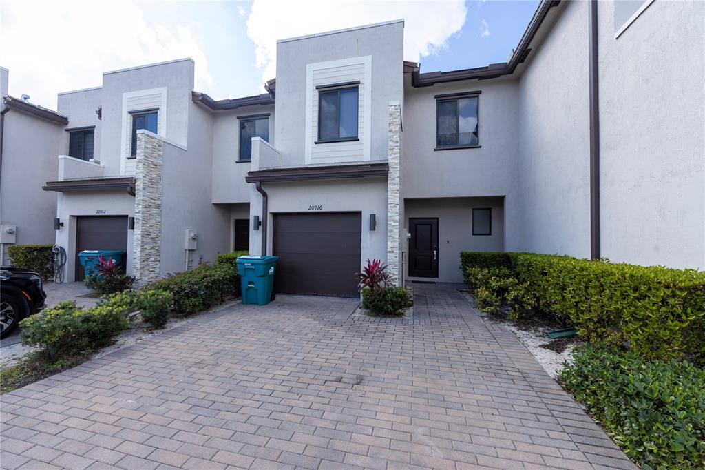 20920 Northeast 8th Avenue Miami, FL 33162 - Photo 17 of 19 a front view of a house with a yard and garage