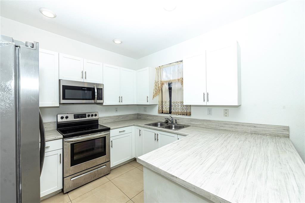 20920 Northeast 8th Avenue Miami, FL 33162 - Photo 2 of 19 a kitchen with a sink stove and microwave