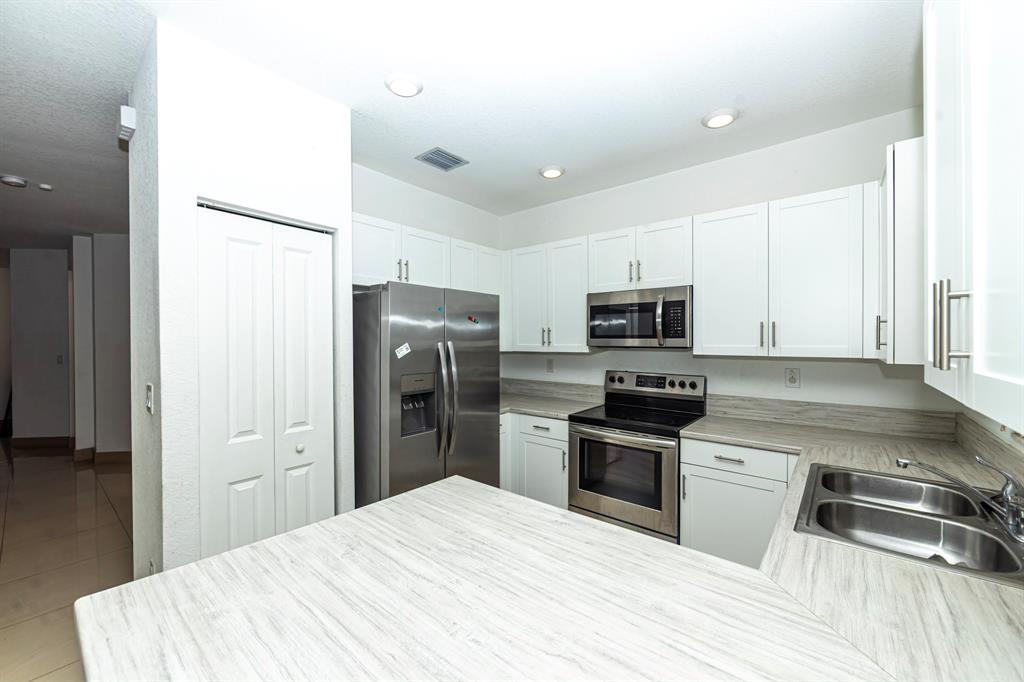 20920 Northeast 8th Avenue Miami, FL 33162 - Photo 3 of 19 a kitchen with granite countertop a refrigerator stove and oven