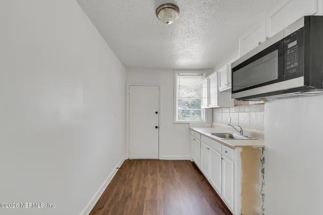 a kitchen with stainless steel appliances granite countertop a sink and a microwave
