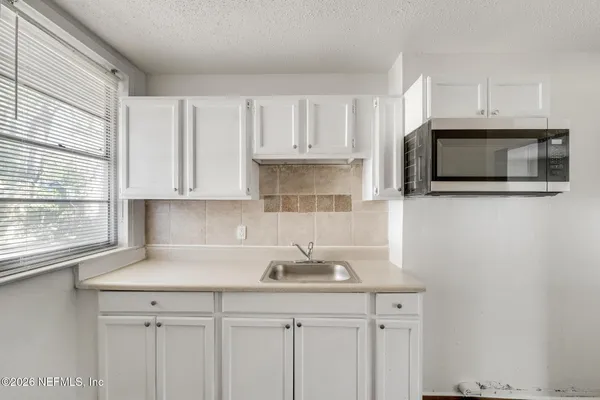 a kitchen with stainless steel appliances a sink a stove and microwave