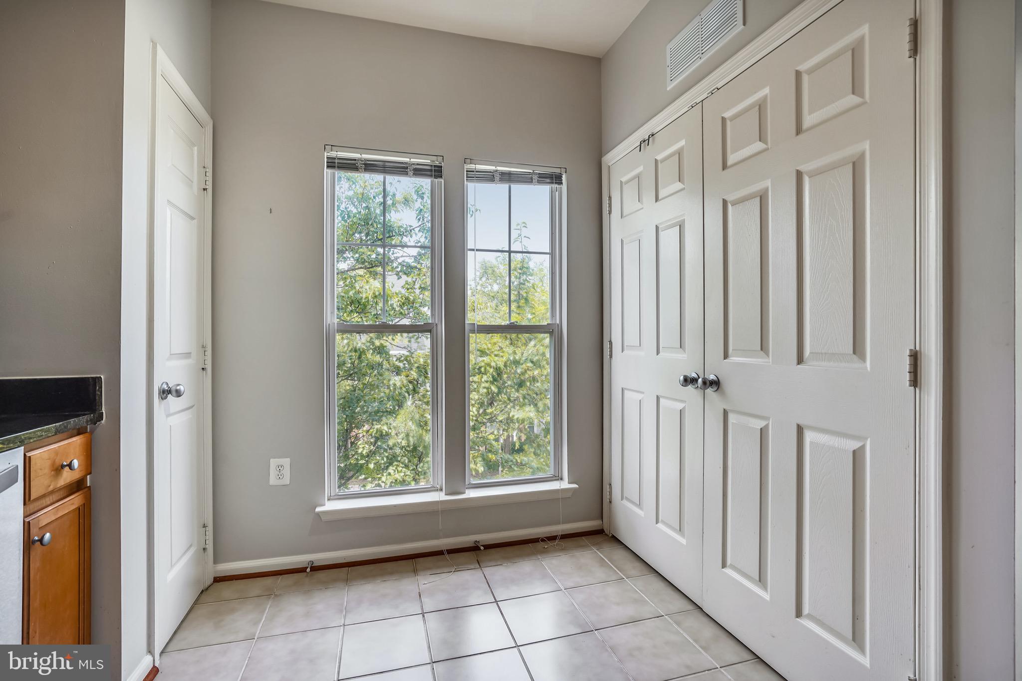 1515 North Point Drive, Unit 301 Reston, VA 20194 - Photo 14 of 32 pantry and washer/dryer tucked behind doors