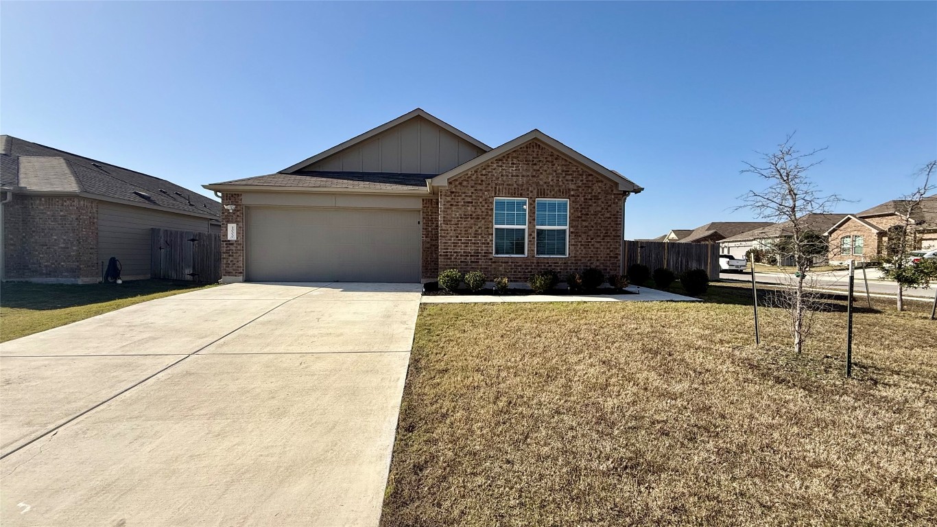 1000 Berryhack Court Hutto, TX 78634 - Photo 1 of 22 View of front facade featuring brick siding, driveway, board and batten siding, and an attached garage