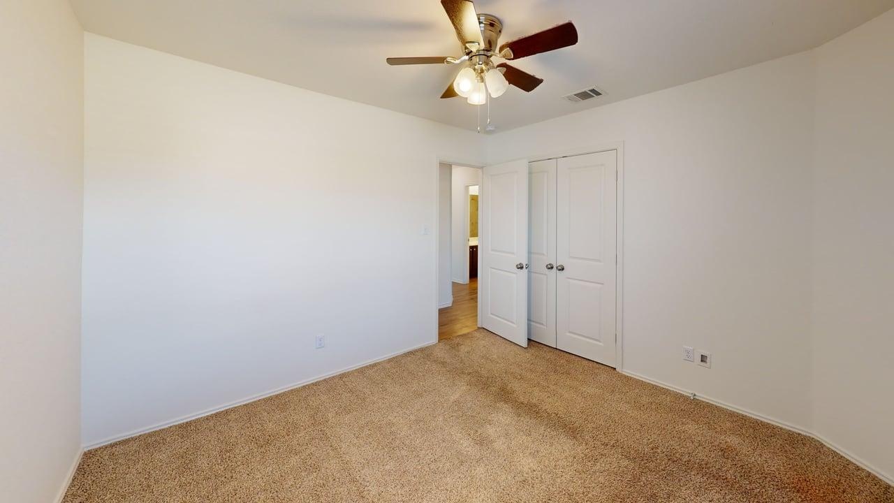 1000 Berryhack Court Hutto, TX 78634 - Photo 12 of 22 Unfurnished bedroom with carpet flooring, ceiling fan, and a closet