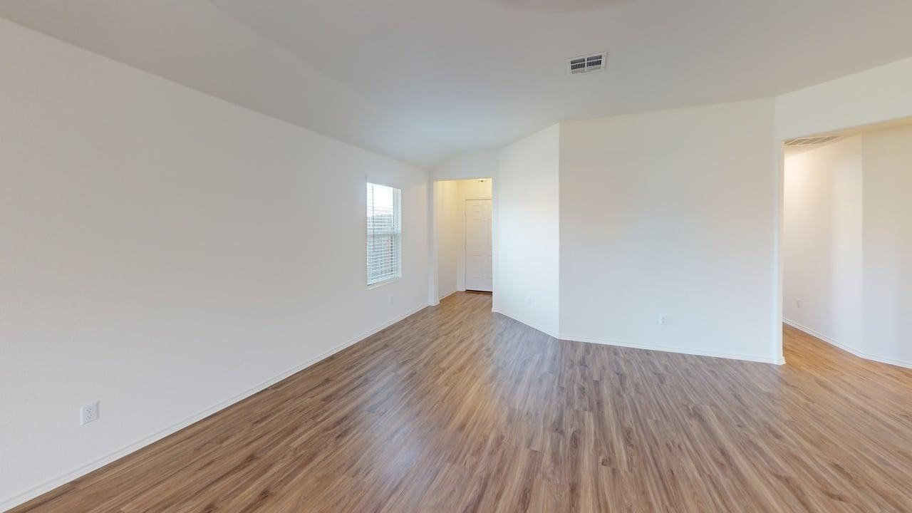1000 Berryhack Court Hutto, TX 78634 - Photo 6 of 22 Unfurnished room with light wood finished floors and vaulted ceiling