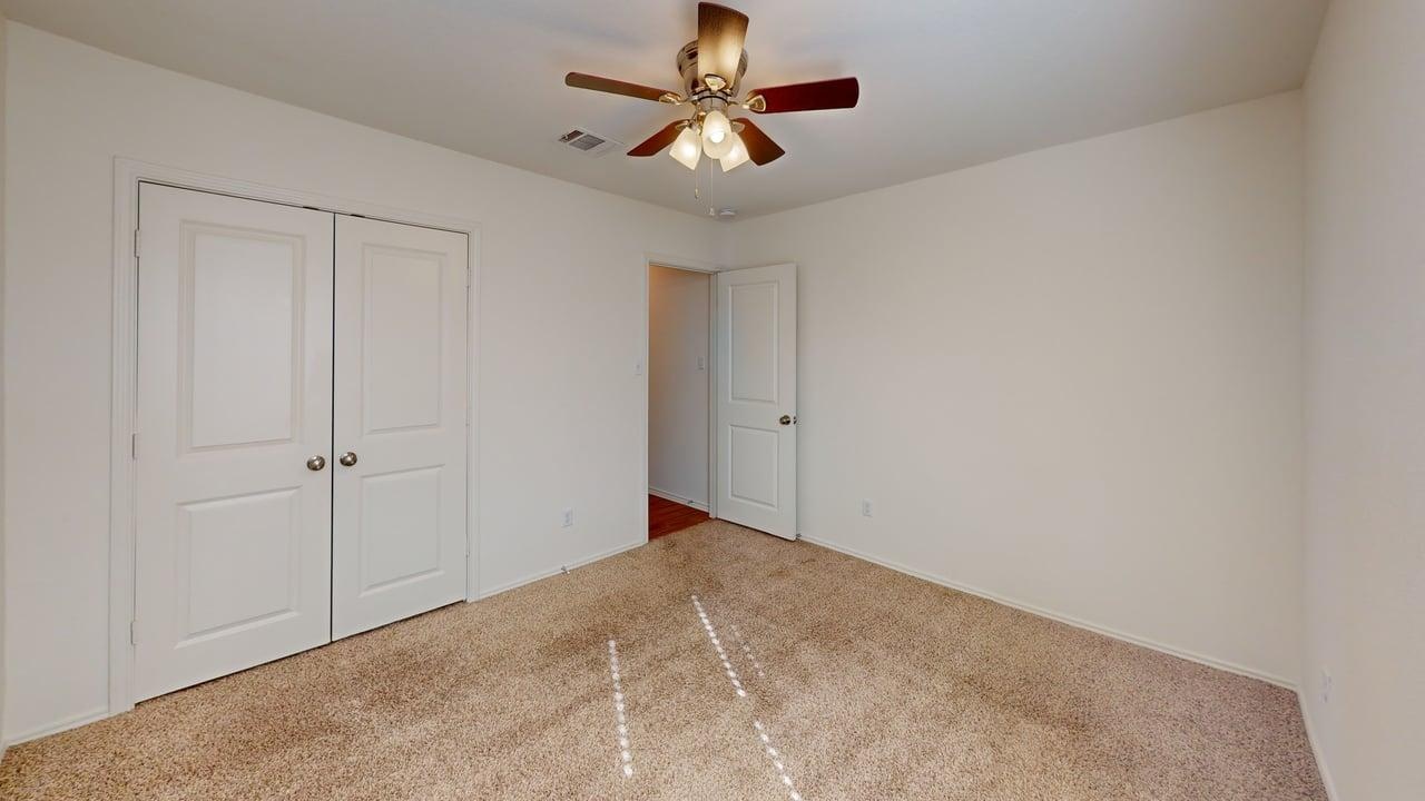 1000 Berryhack Court Hutto, TX 78634 - Photo 9 of 22 Unfurnished bedroom with carpet floors, a closet, and a ceiling fan