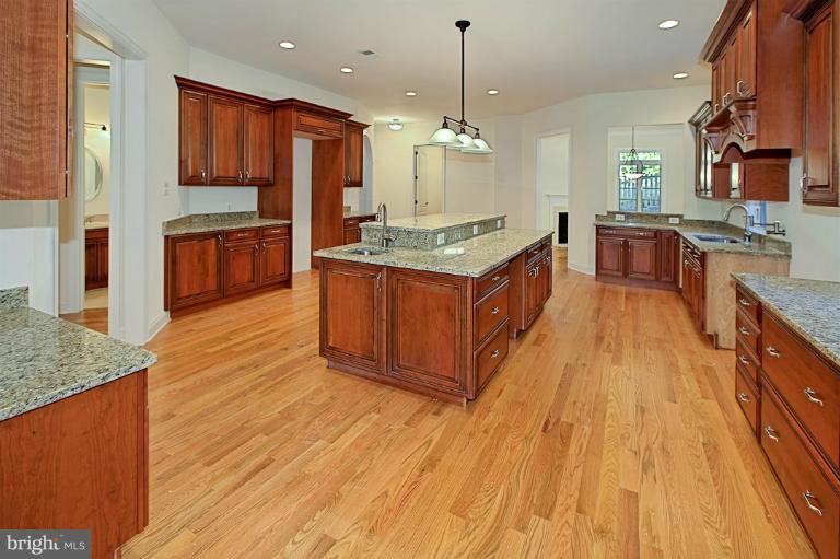 6010 Chesterbrook Road McLean, VA 22101 - Photo 14 of 30 a large kitchen with stainless steel appliances kitchen island granite countertop wooden floors and a view of living room