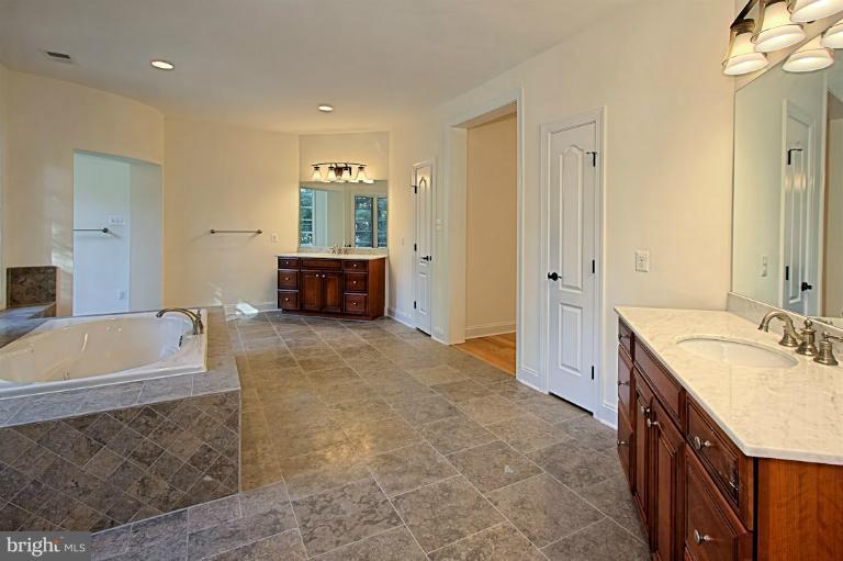 6010 Chesterbrook Road McLean, VA 22101 - Photo 22 of 30 a spacious bathroom with a tub sink shower and mirror