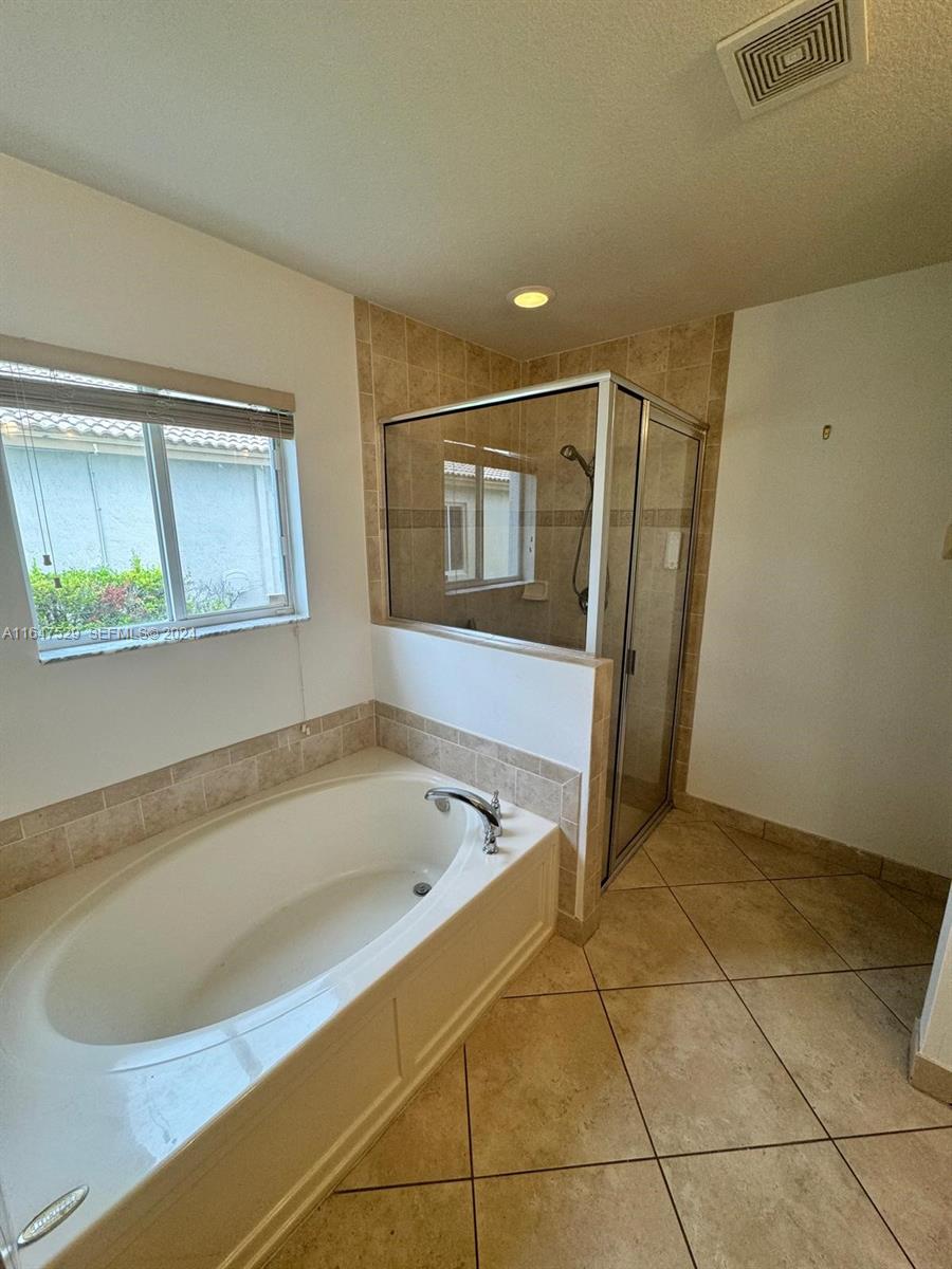 4527 Southwest 129th Avenue Miramar, FL 33027 - Photo 11 of 28 a bathroom with a bathtub and a shower