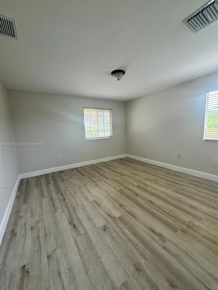 4527 Southwest 129th Avenue Miramar, FL 33027 - Photo 15 of 28 an empty room with wooden floor and windows