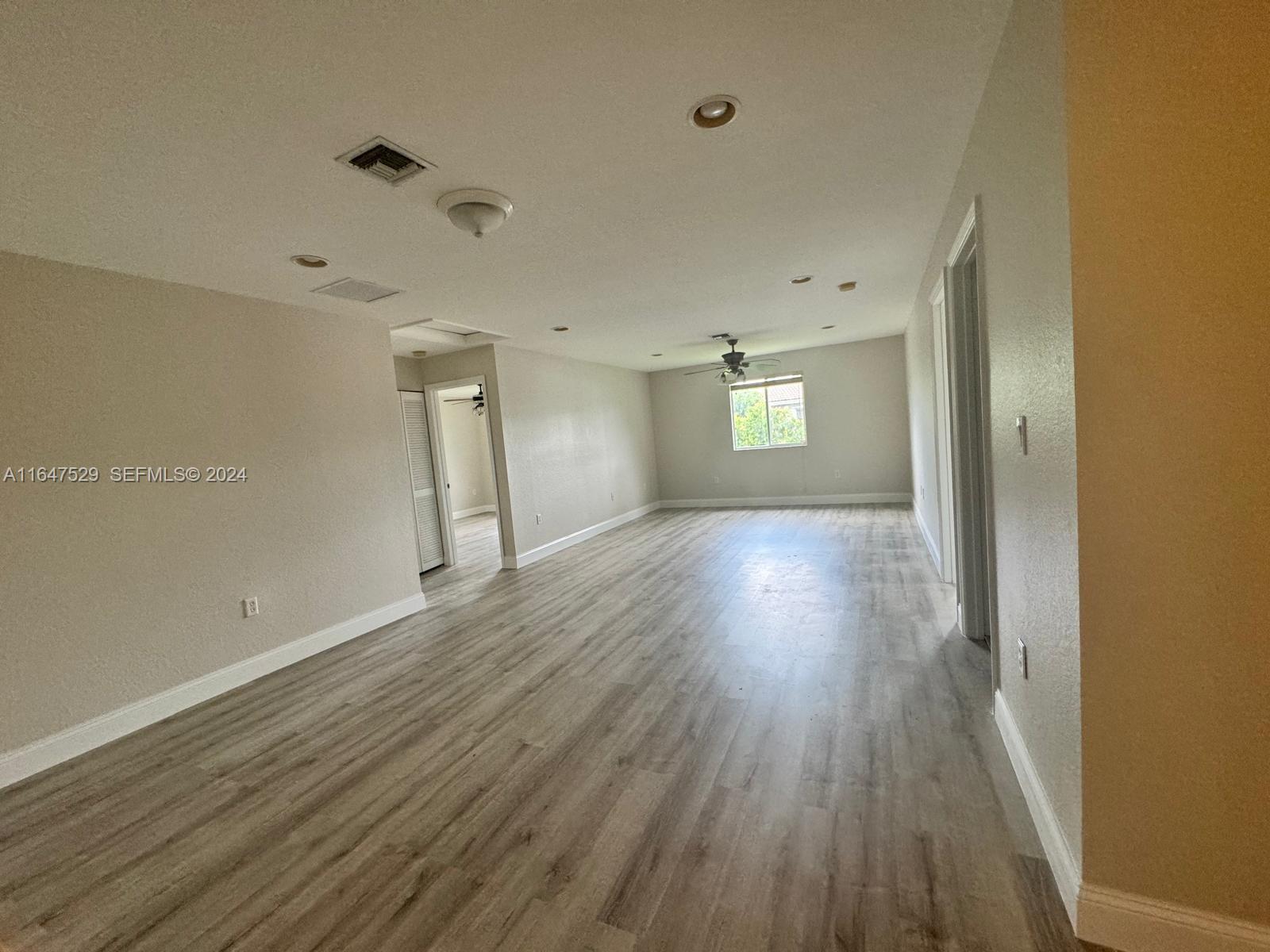 4527 Southwest 129th Avenue Miramar, FL 33027 - Photo 19 of 28 an empty room with wooden floor and windows