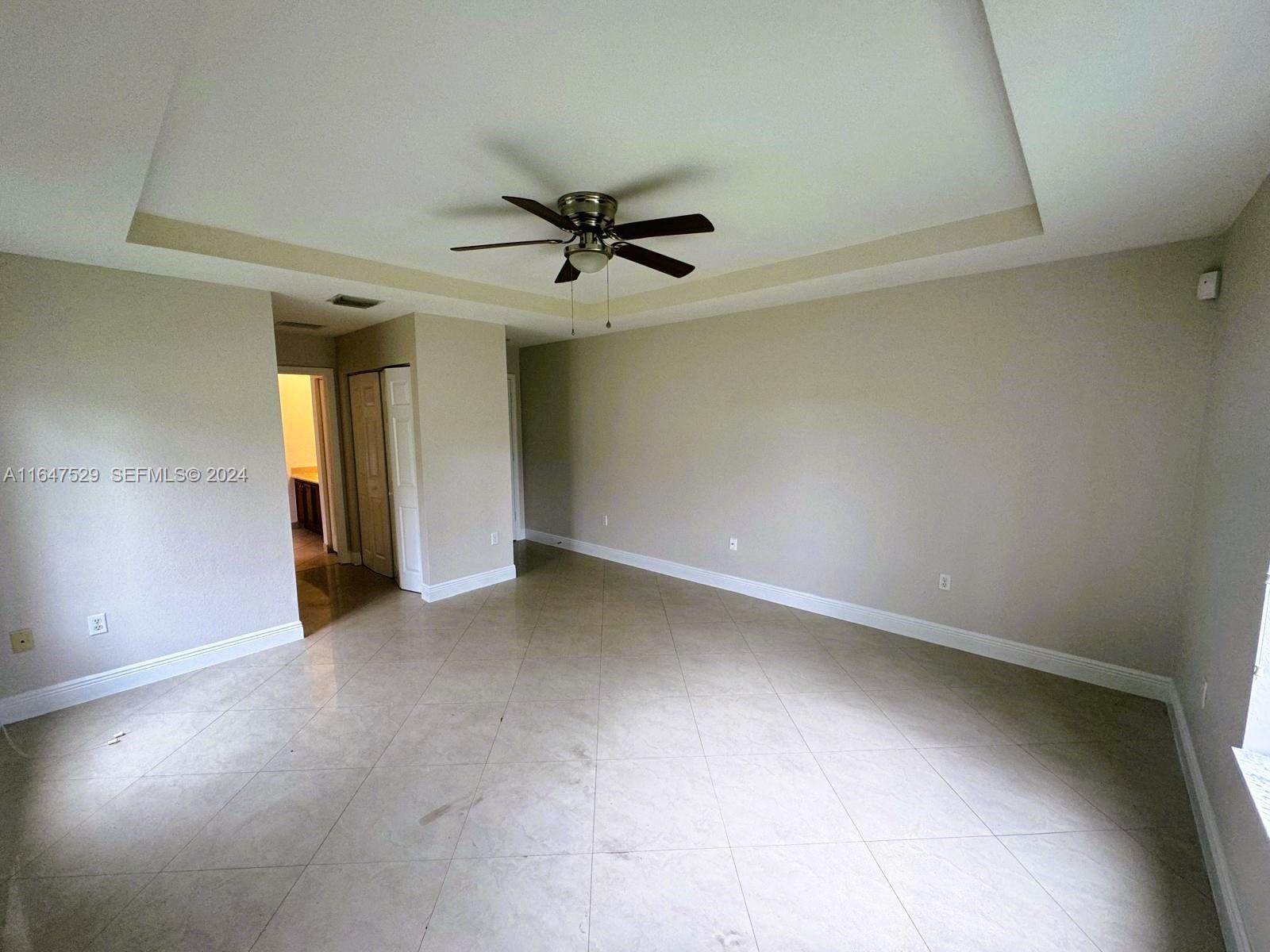 4527 Southwest 129th Avenue Miramar, FL 33027 - Photo 8 of 28 an empty room with a ceiling fan and carpet