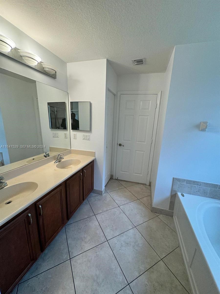4527 Southwest 129th Avenue Miramar, FL 33027 - Photo 10 of 28 a bathroom with a sink a mirror and a bathtub