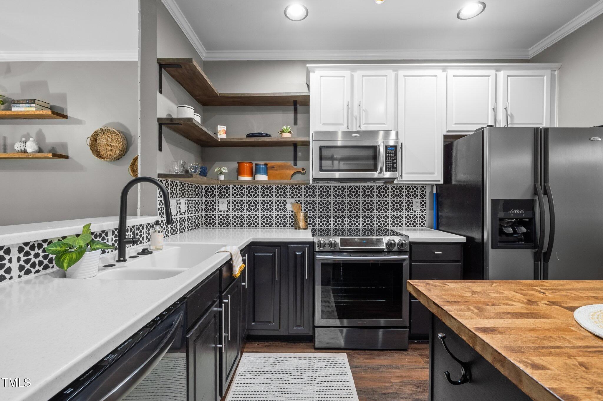 214 Cedar Elm Road Durham, NC 27713 - Photo 8 of 35 a kitchen with stainless steel appliances granite countertop a sink stove and refrigerator