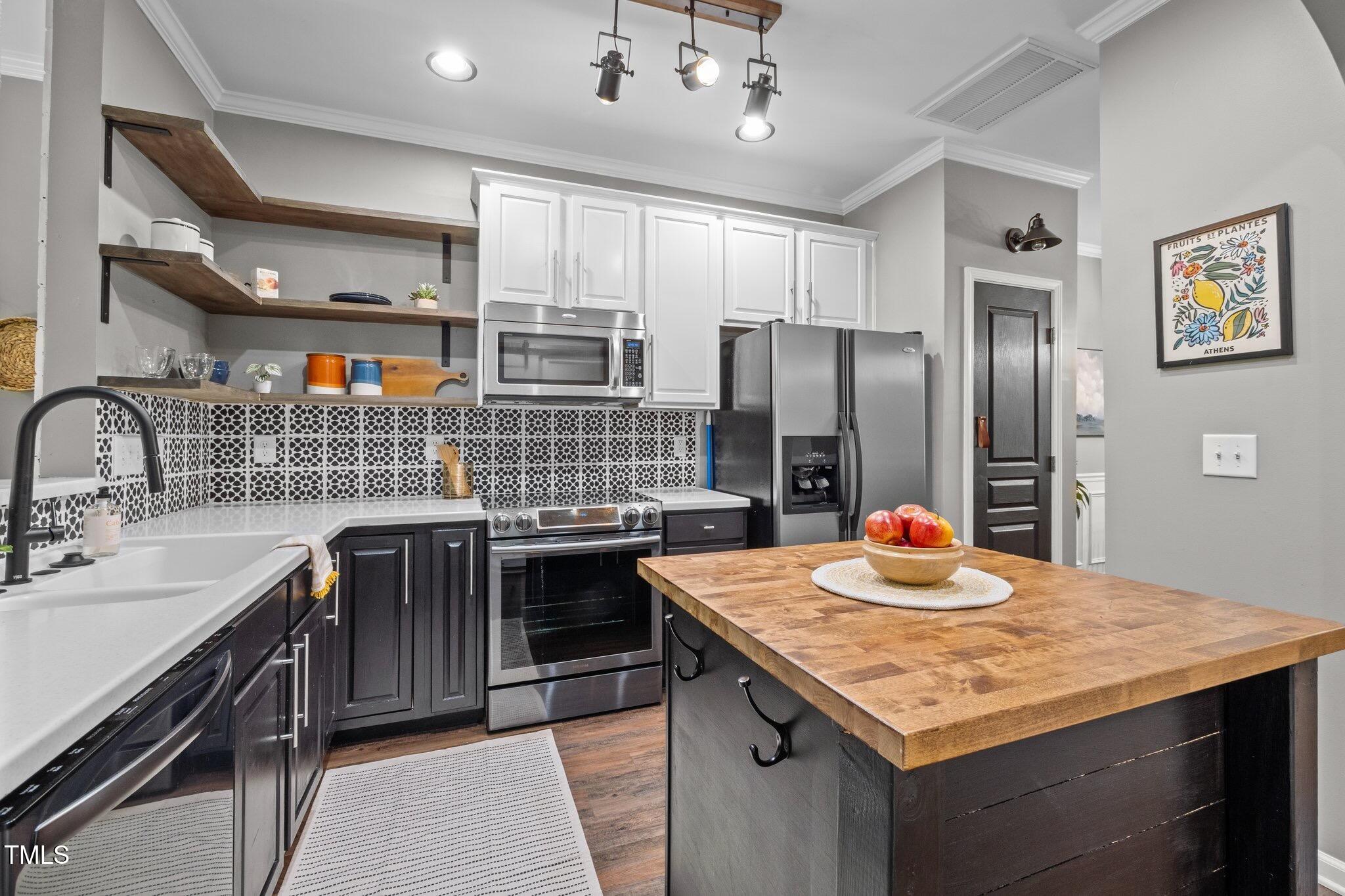214 Cedar Elm Road Durham, NC 27713 - Photo 9 of 35 a kitchen with stainless steel appliances granite countertop a sink stove and refrigerator