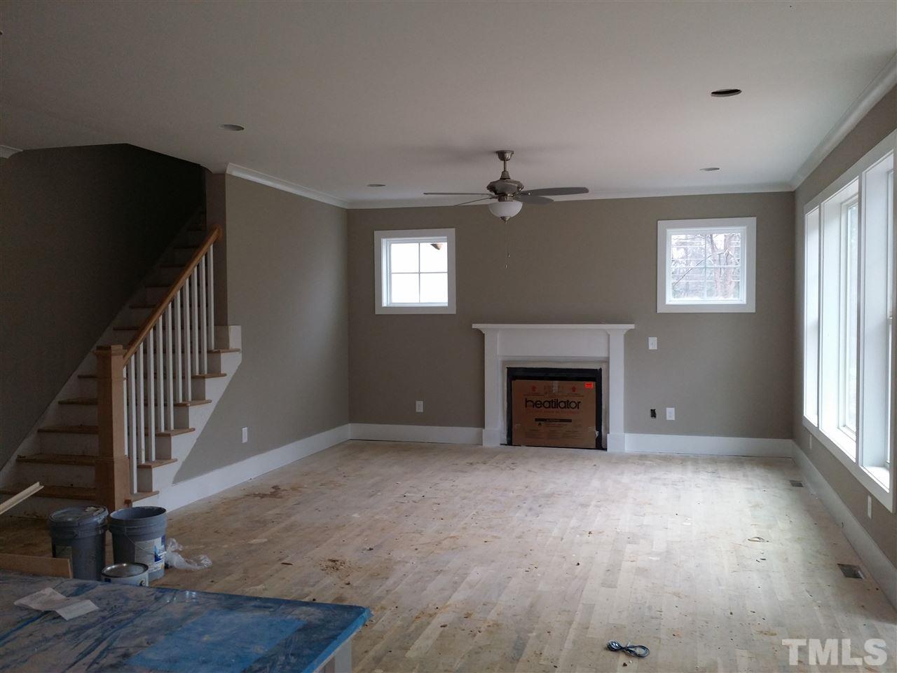 805 Edmund Street Raleigh, NC 27604 - Photo 4 of 13 a view of an empty room with wooden floor fireplace and a window