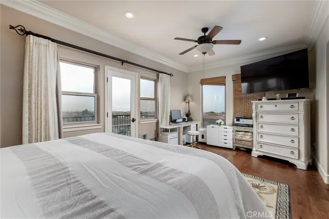 a spacious bedroom with a bed and a flat tv screen on dresser