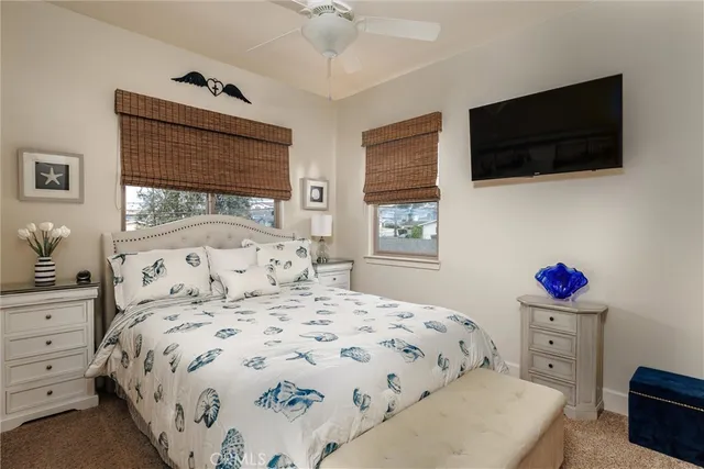 a bedroom with a bed a flat screen tv and a window