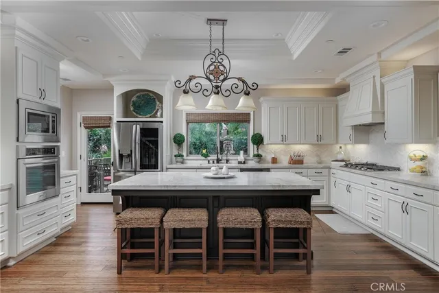 a kitchen with stainless steel appliances granite countertop a dining table and chairs