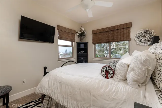 a bedroom with a large bed and a flat tv screen on dresser