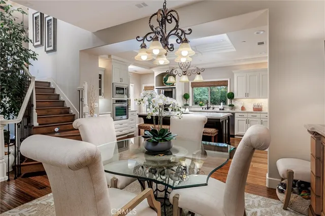 a view of a dining room with furniture a chandelier and wooden floor
