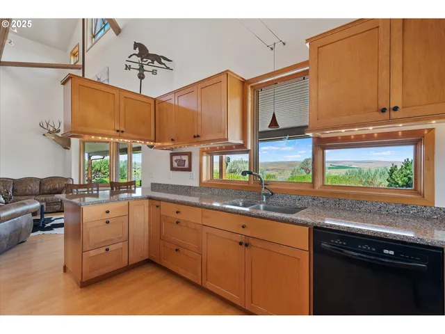 a kitchen with stainless steel appliances granite countertop a sink dishwasher and cabinets with wooden floor