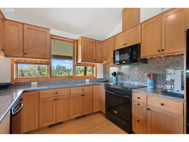 a kitchen with stainless steel appliances granite countertop a sink a stove and a microwave