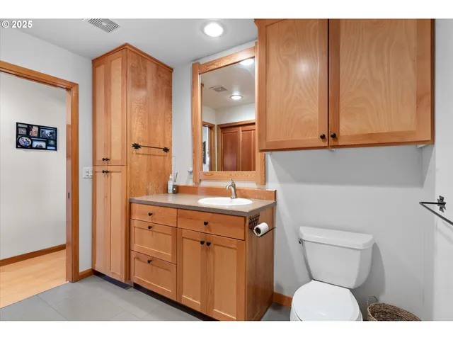 a bathroom with a toilet a sink and mirror