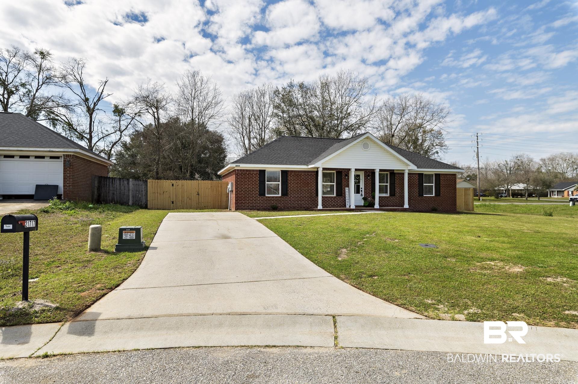 21717 Shadowbrook Street Robertsdale, AL 36567 - Photo 31 of 32 View of front of home featuring brick siding, covered porch, a gate, fence, and a front lawn