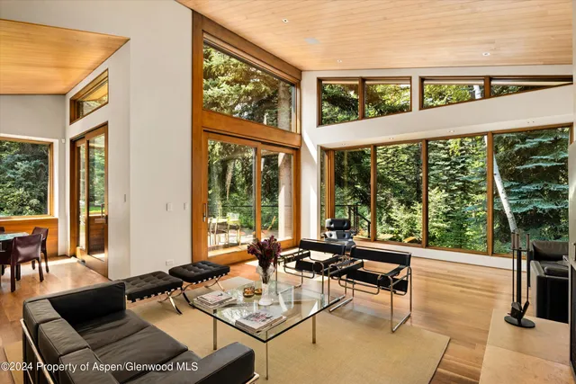 a kitchen with stainless steel appliances granite countertop a stove top oven a sink a dining table and chairs