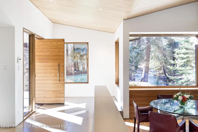 a view of a living room and floor to ceiling window with an outdoor view