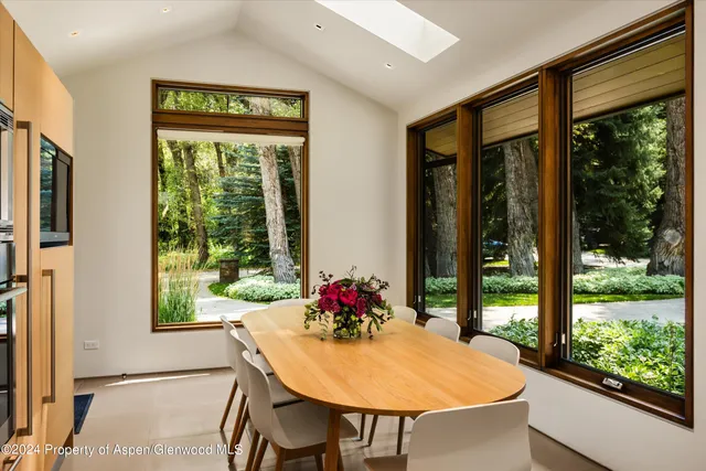 a living room with furniture tv and a floor to ceiling window
