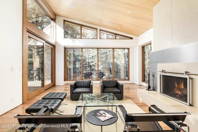 a living room with fireplace furniture and a floor to ceiling window