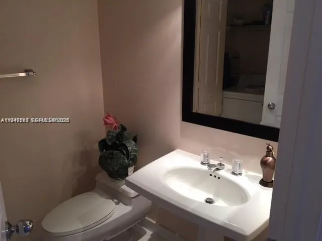 a bathroom with a sink toilet and mirror