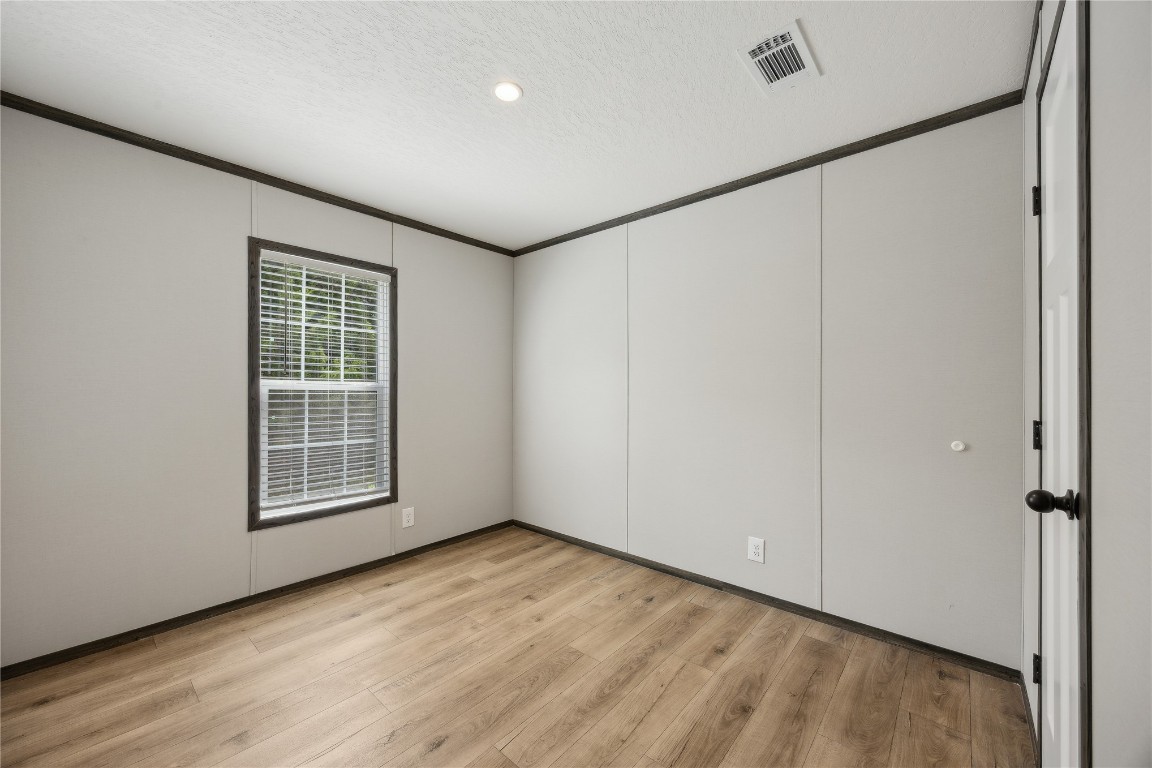 85128 Angie Road Yulee, FL 32097 - Photo 12 of 14 a view of an empty room with wooden floor and a window