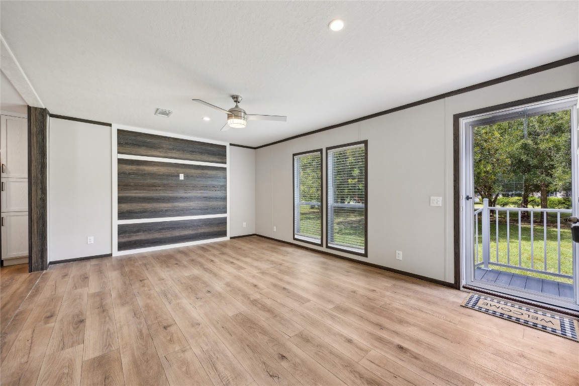 85128 Angie Road Yulee, FL 32097 - Photo 5 of 14 a view of empty room with wooden floor and fan