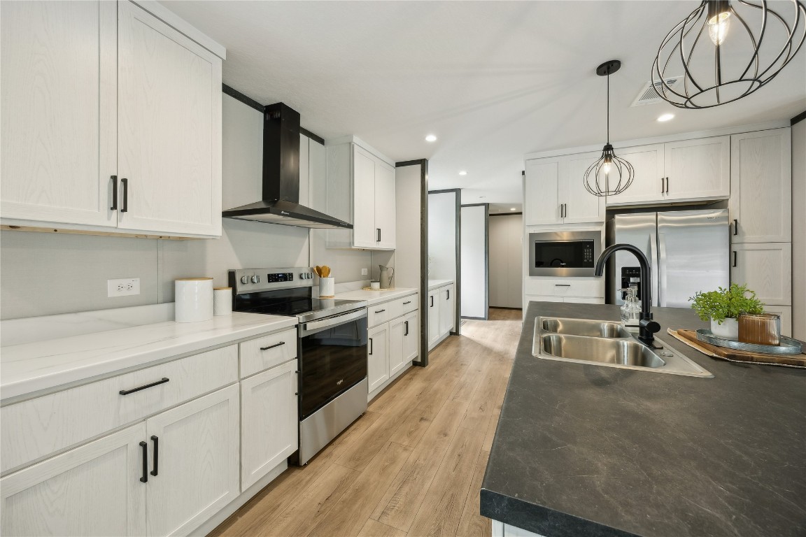 85128 Angie Road Yulee, FL 32097 - Photo 7 of 14 a kitchen with granite countertop a stove a sink a refrigerator and a stove top oven with white cabinets